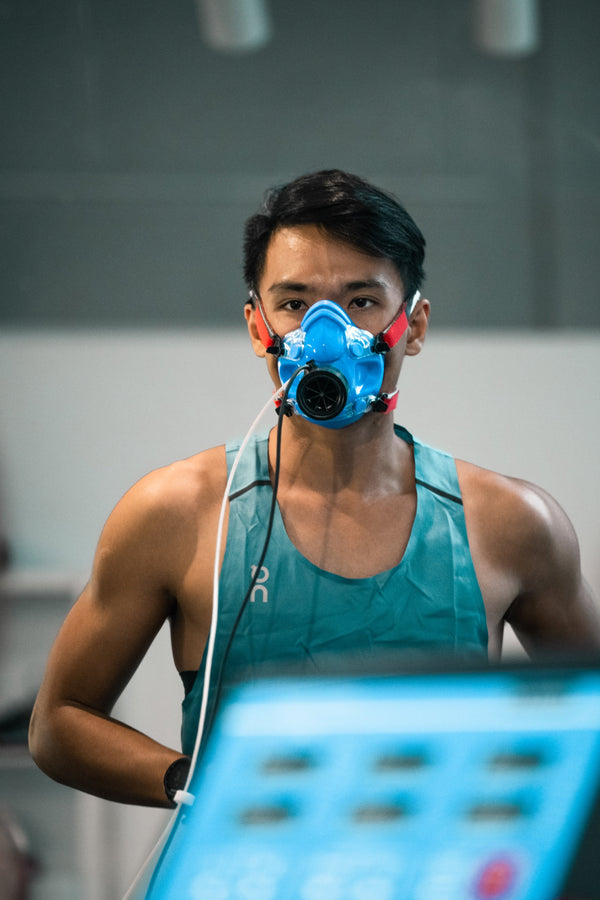 Athlete wearing a blue respiratory mask during a run metabolic test in the Coached Lab